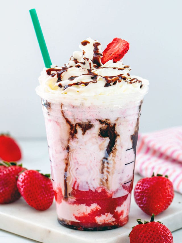 Head-on view of a chocolate covered strawberry Frappuccino with whipped cream topping and green straw.