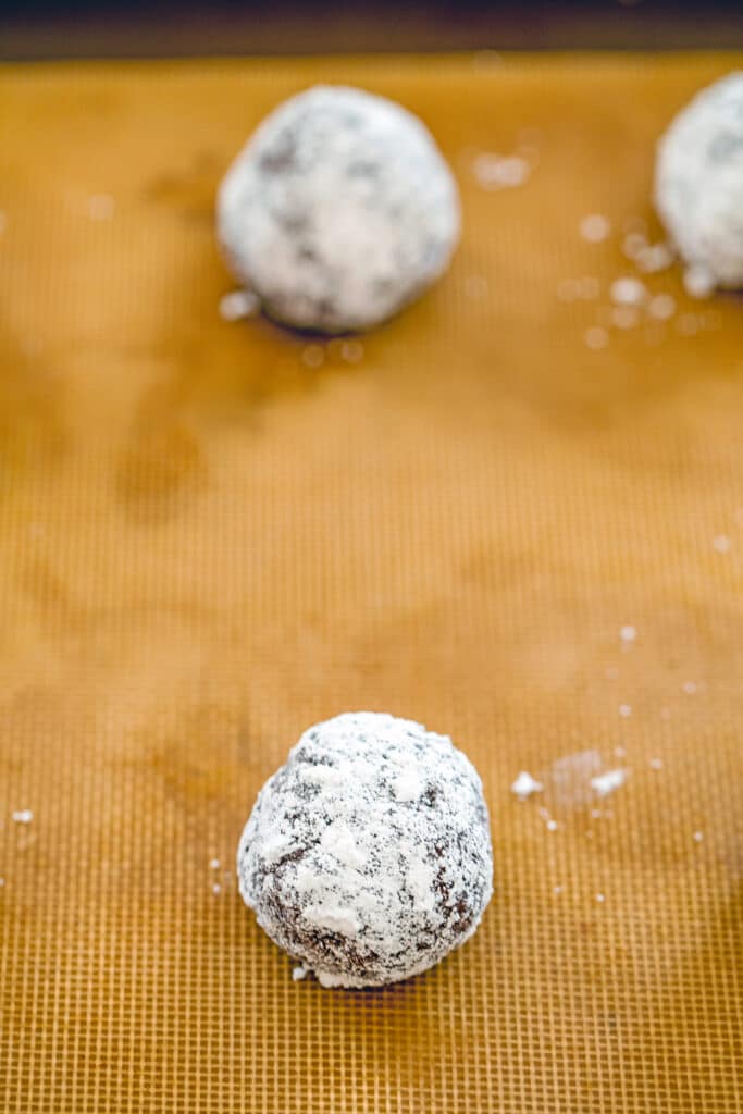 Overhead view of cookie batter rolled into balls on baking sheet