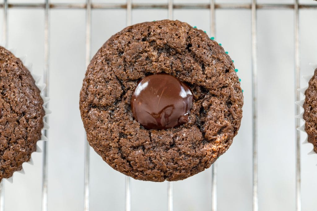 Overhead view of chocolate stout cupcake with core cut out and filled with Irish whiskey ganache filling