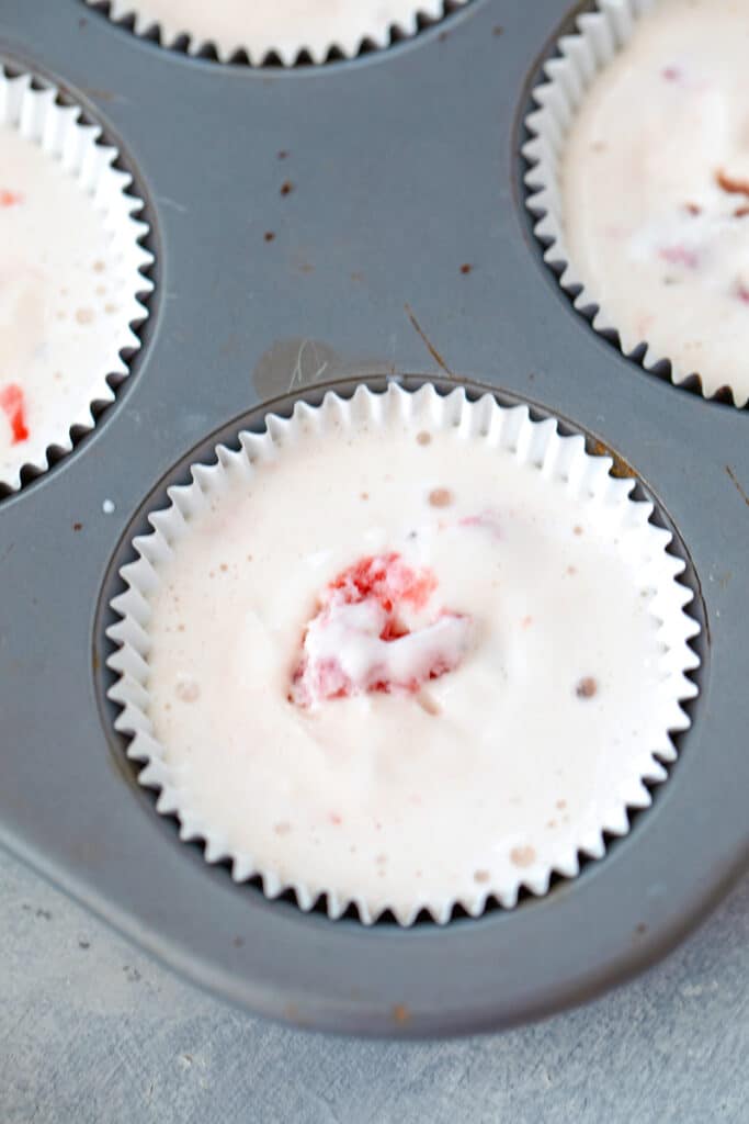 Strawberry ice cream in cupcake papers in tin