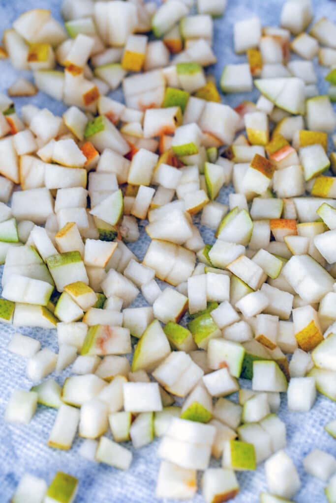 Chopped pears on a paper towel-lined baking sheet