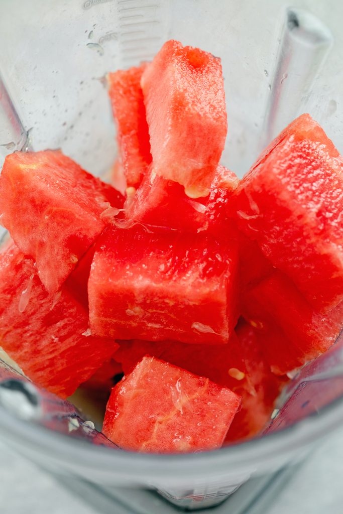 Overhead view of cubed watermelon, tequila, lime juice, and Triple Sec in blender