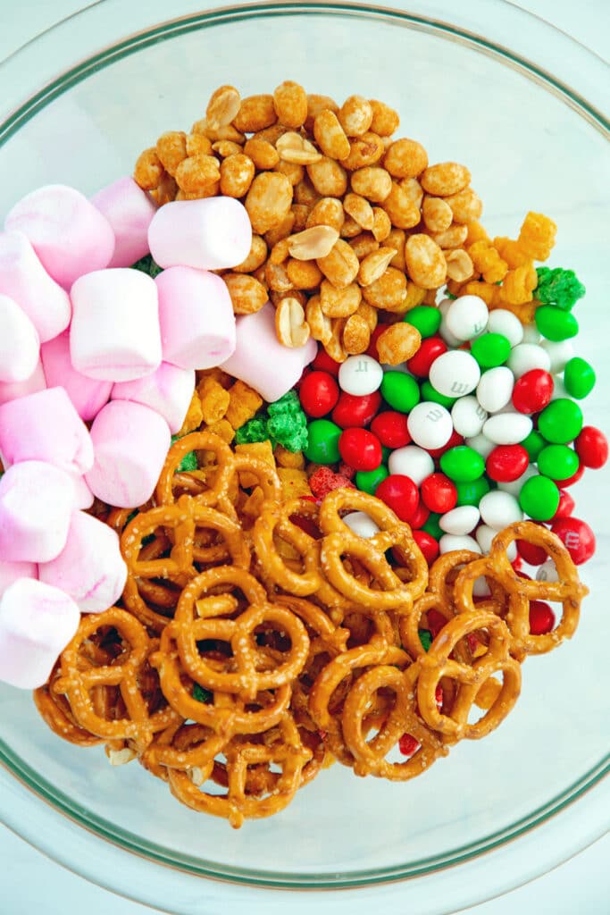 Christmas Cap'n Crunch, pink marshmallows, mini pretzels, red and green M&Ms, and peanuts in a bowl