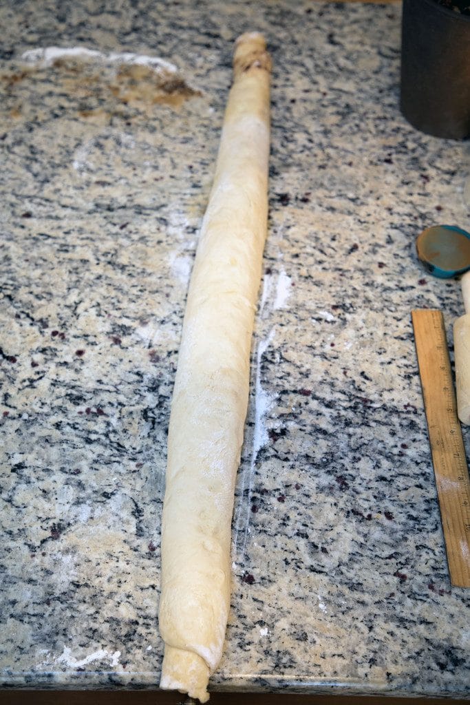 Cinnamon roll dough rolled up on counter