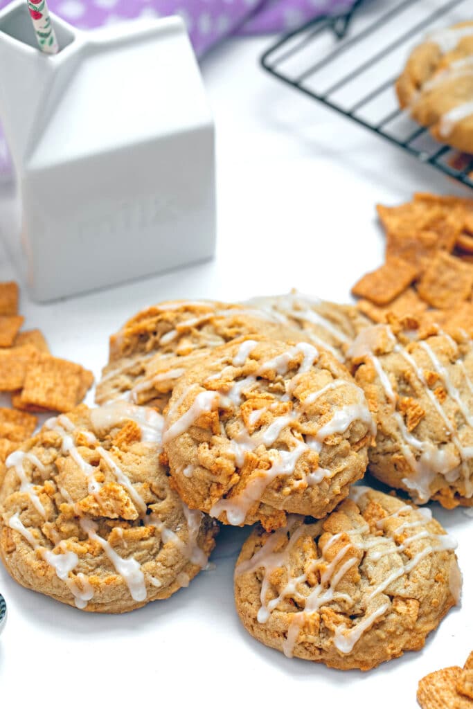 Overhead view of multiple Cinnamon Toast Crunch cookies with ceramic milk carton in background.