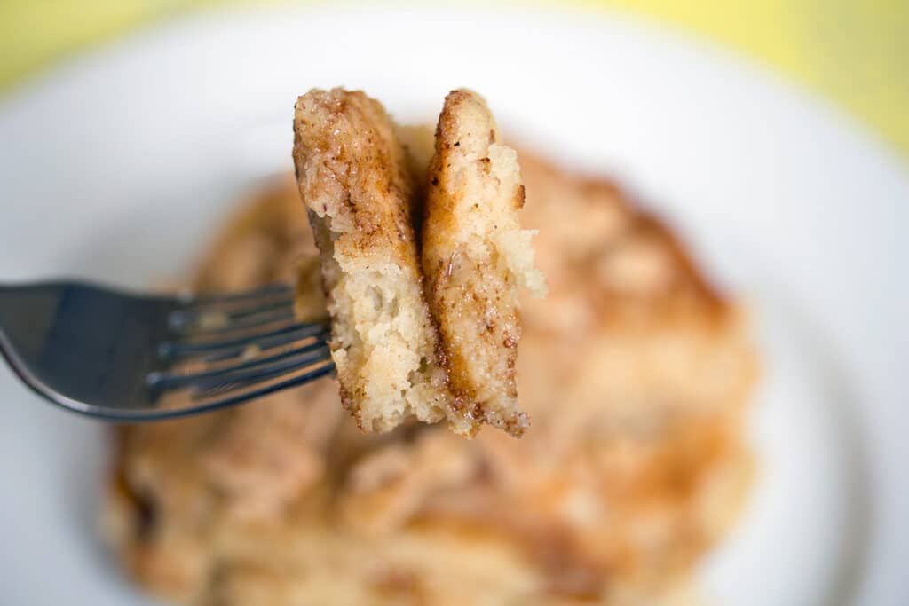 Landscape close-up view of a fork holding up two bites of Cinnamon Toast Crunch pancakes