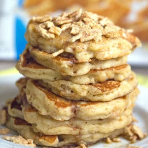 Head-on closeup view of a stack of cinnamon toast crunch pancakes with crushed Cinnamon Toast Crunch cereal on top