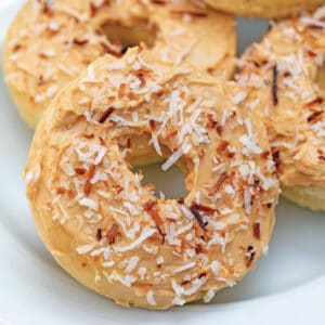 Close-up view of a coconut doughnuts with salted caramel icing and toasted coconut on top