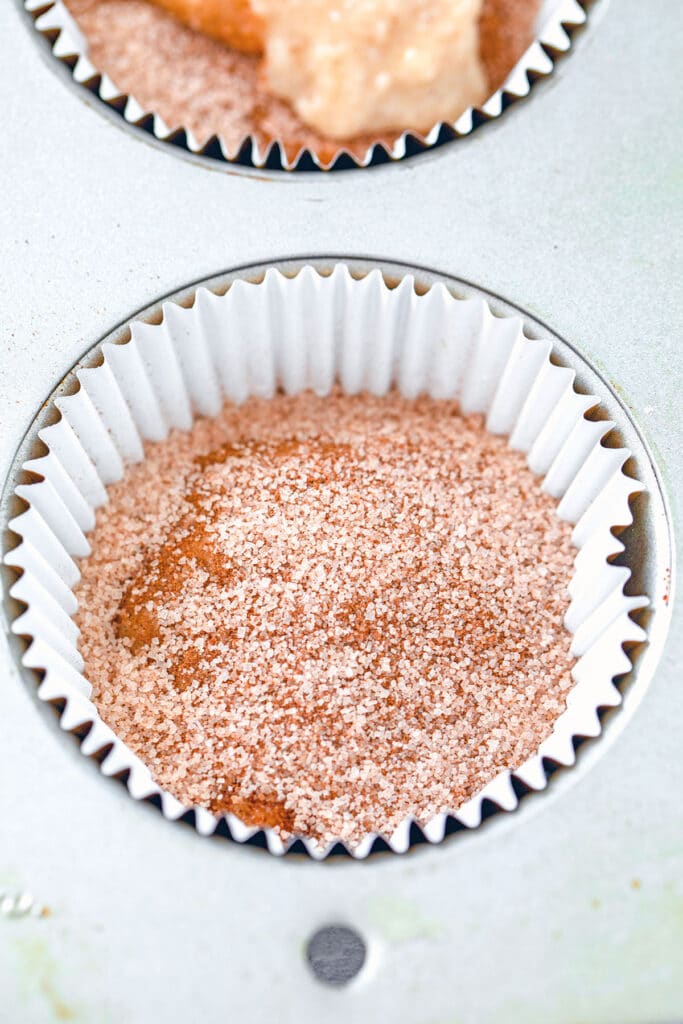 Cupcake papers with batter topped with cinnamon sugar