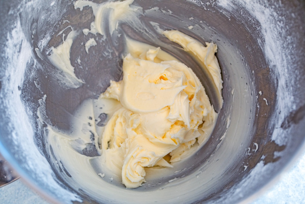 Overhead view of buttercream icing in mixing bowl.
