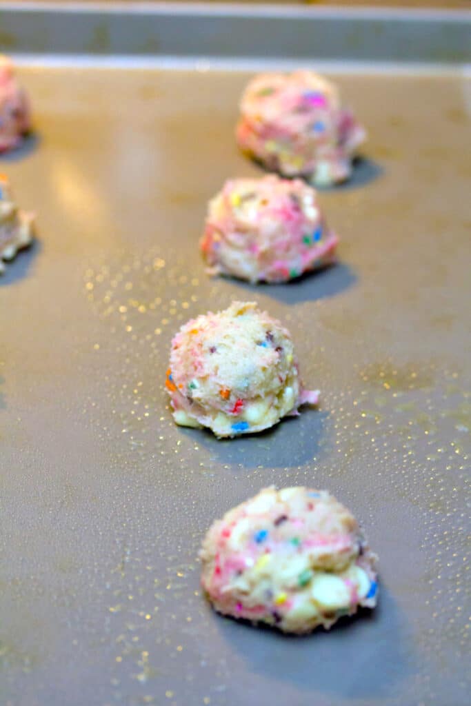 Strawberry milk cookie dough scooped on a baking sheet