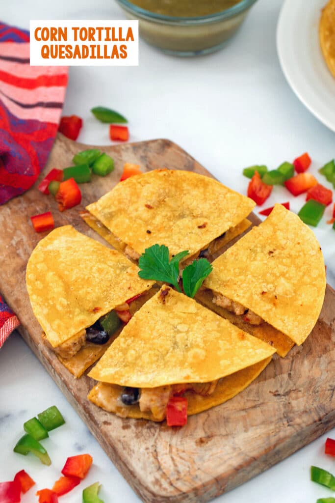 Overhead view of a corn tortilla quesadilla cut into four wedges with peppers all around, salsa in background, and recipe title at top.
