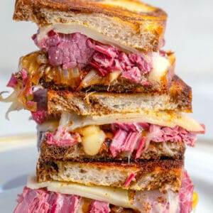 Close-up view of corned beef melt sandwich halves stacked one each other