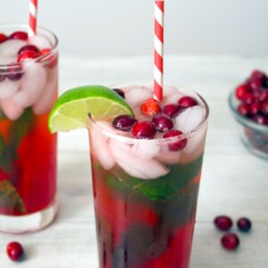 Cranberry Mojitos -- If you think mojitos are a summer-only cocktail, let these Cranberry Mojitos change your mind! This perfect holiday cocktail is made with homemade cranberry simple syrup, lime, rum, and plenty of mint | wearenotmartha.com
