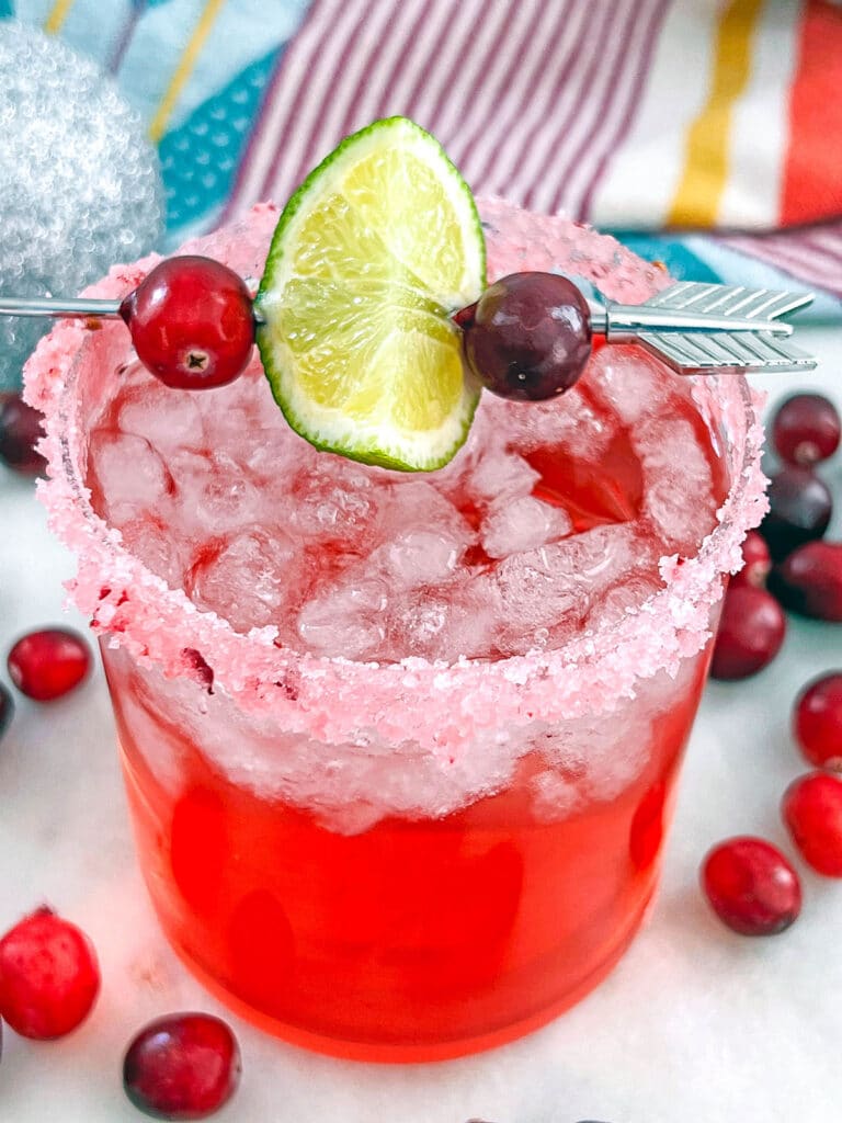 Overhead view of a cranberry drink in a glass with a cranberry sugar rim