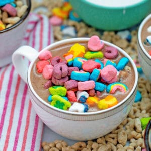 Head-on view of Lucky Charms hot chocolate topped with cereal marshmallows with cereal all around