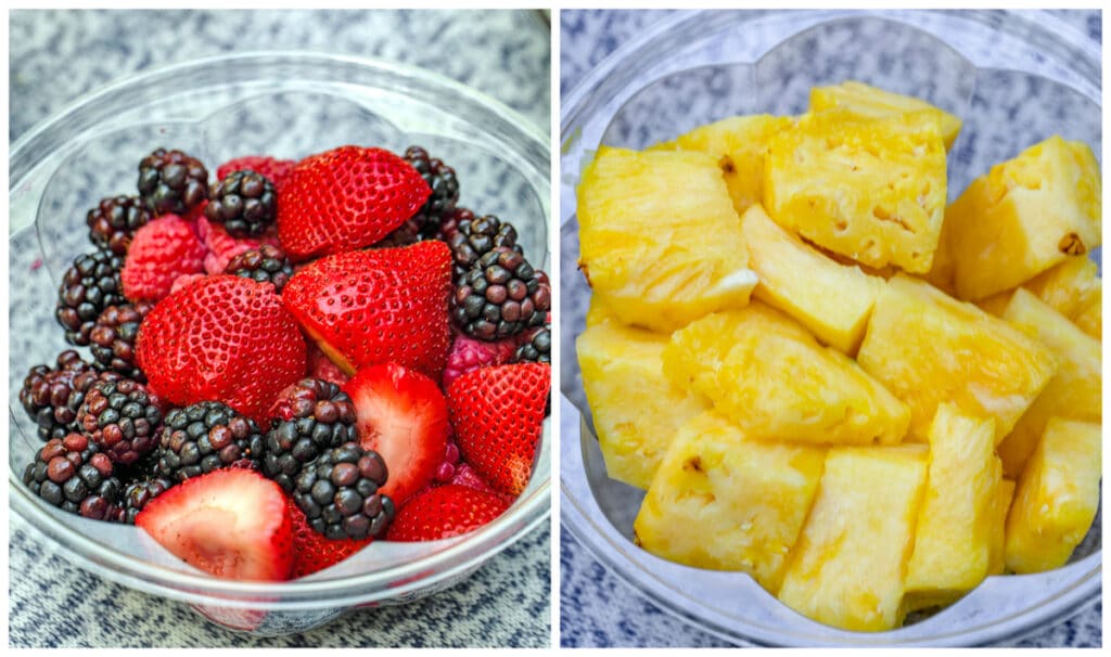 Fresh strawberries, raspberries, and blackberries in container and fresh cut pineapple in container.