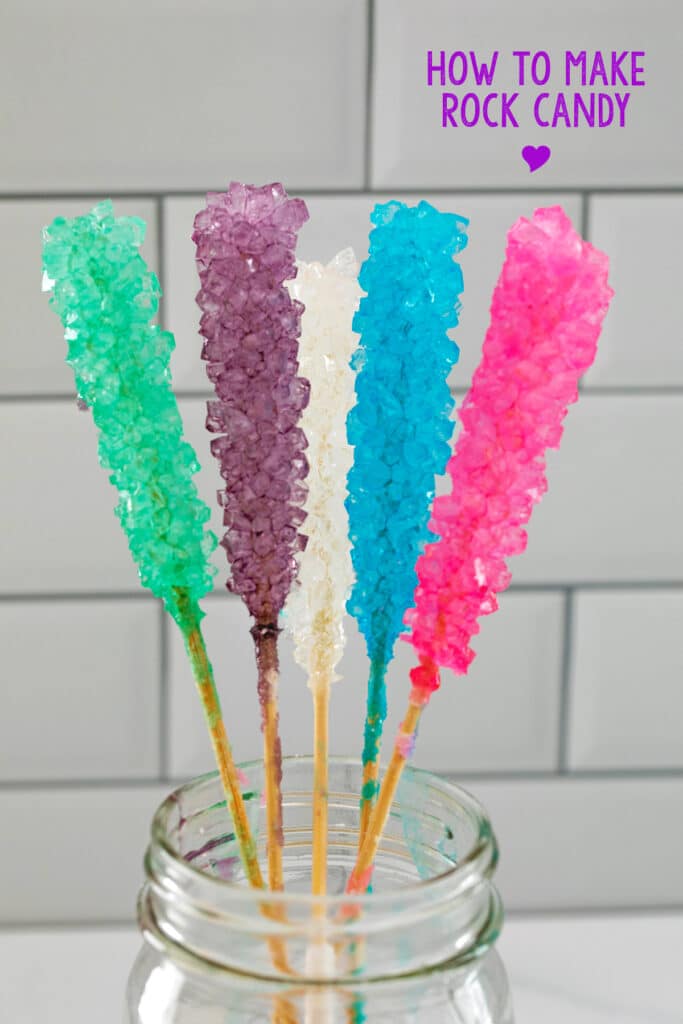Close-up of 5 different colors rock candy in mason jar with "DIY Rock Candy" label at top