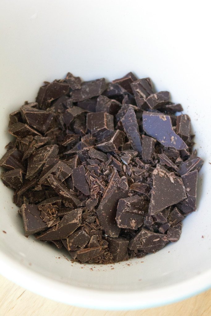 Overhead view of chopped dark chocolate in a bowl.