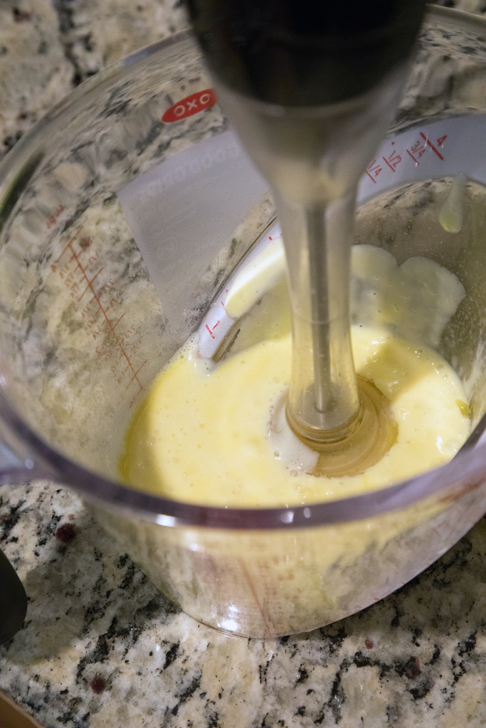 Immersion blender in a measuring cup making homemade hollandaise sauce