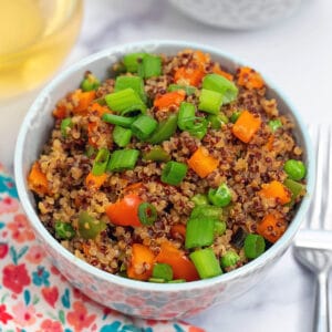 Close-up of quinoa fried rice made with red and white quinoa, bell peppers, carrots, and scallions