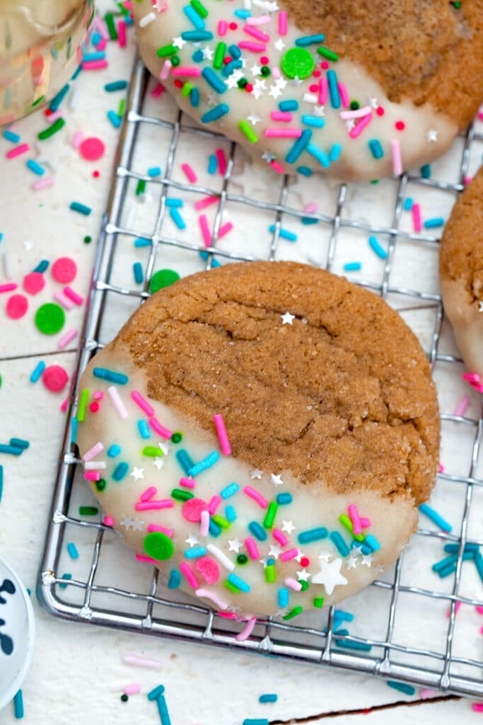 Close-up view of a eggnog gingerbread cookie coated in sprinles on a metal rack