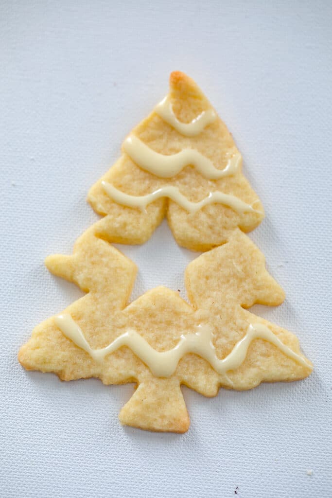 Christmas tree shortbread cookie with icing drizzled on it
