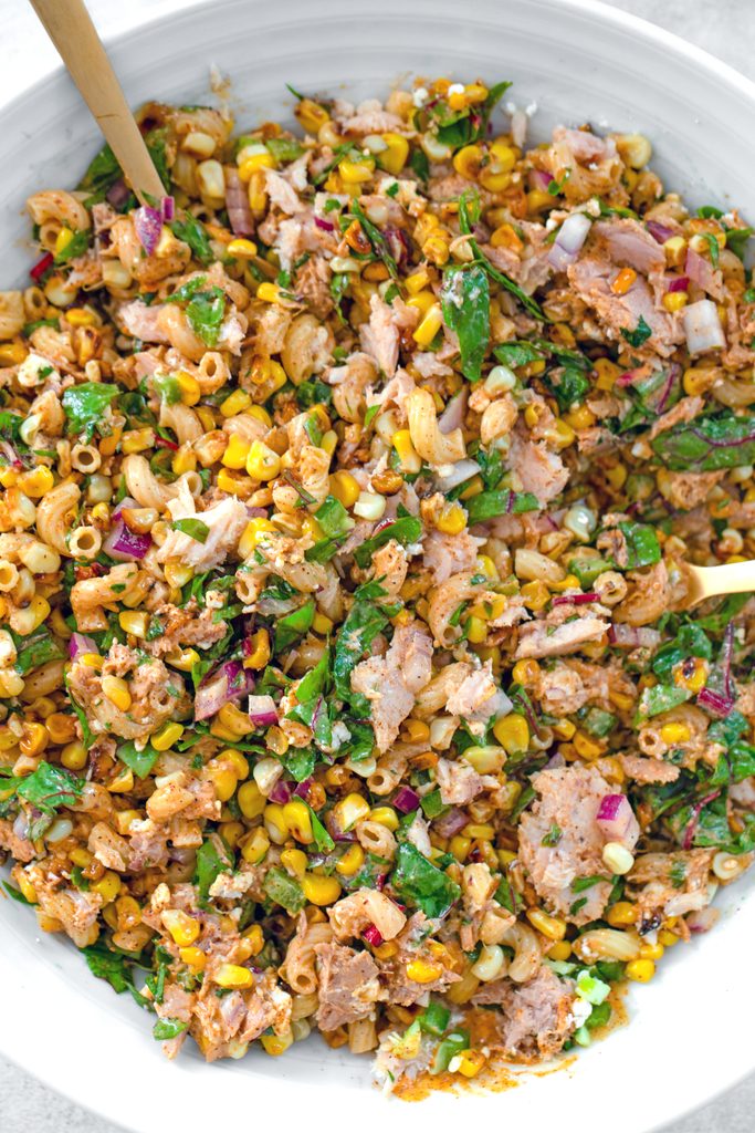 Overhead view of a white serving bowl filled with elote tuna salad all tossed together