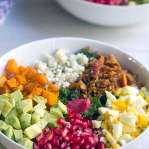 Fall Cobb Salad with Cranberry Dressing -- With kale, butternut squash, hardboiled egg, pomegranate, cranberry dressing, and more, this Fall Cobb Salad is the perfect balance of healthy and indulgent! | wearenotmartha.com