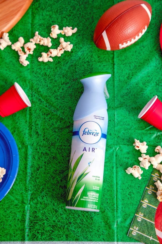 Bird's eye view of Febreze AIR on football field tablecloth with spilled popcorn, mini footballs, cups and plates