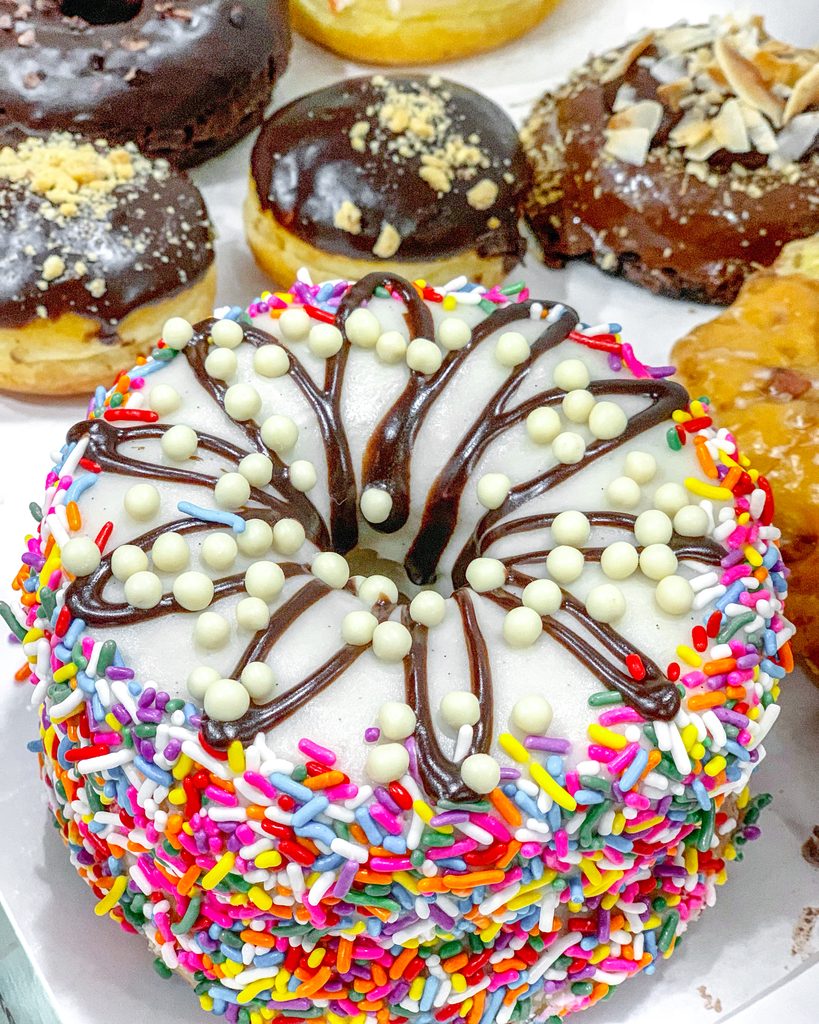 Overhead view of various donuts from Chicago's Firecakes, including the sprinkles covered birthday cake donut