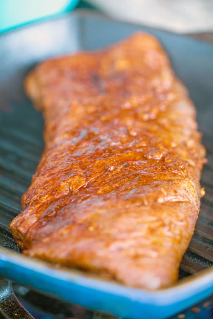 Overhead view of flank steak being cooked in grill pan