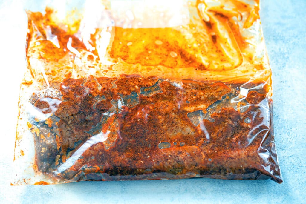 Overhead view of steak marinating in large ziplock bag