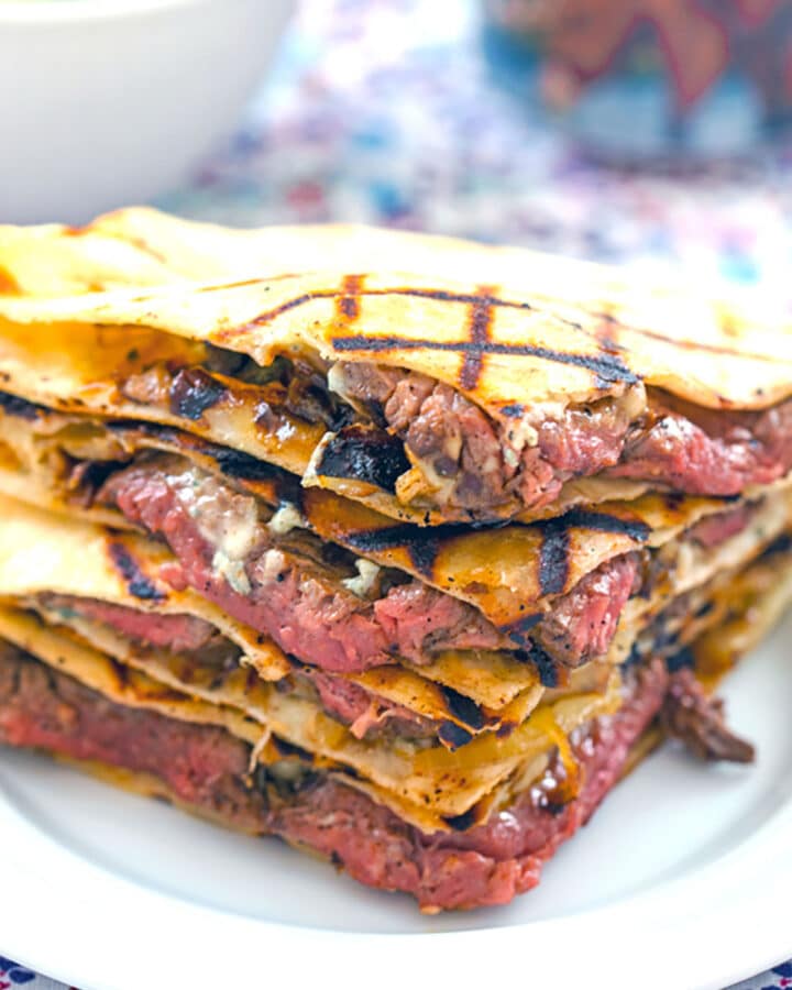 Head-on view of flank steak quesadillas with gorgonzola stacked on each other