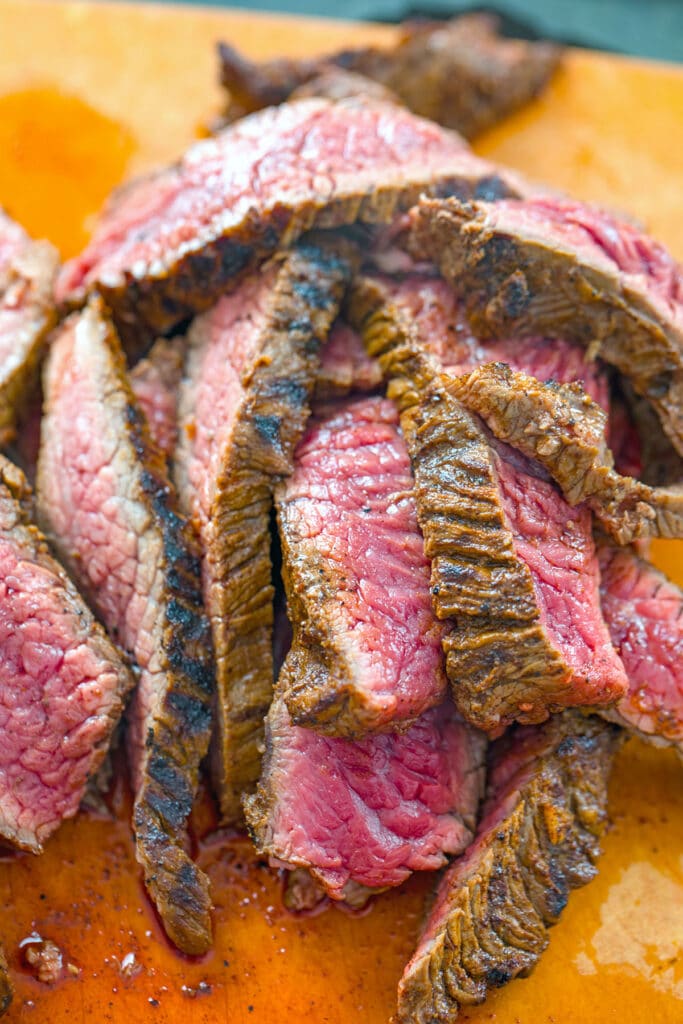 Flank steak sliced against the grain on a cutting board