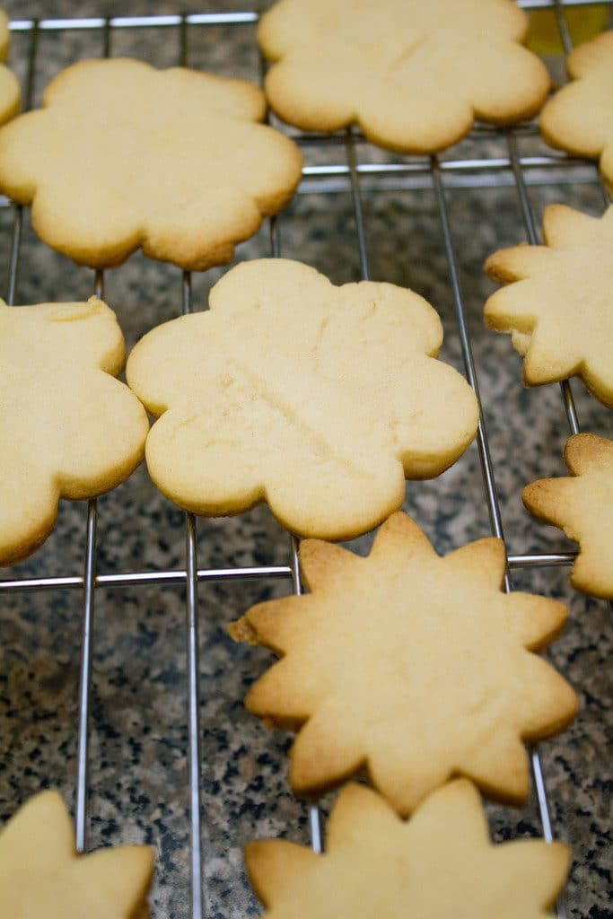 Overhead view of baked flower sugar cookies cooling on baking rack