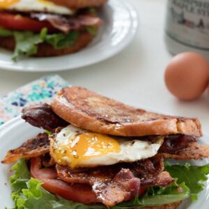 French Toast BLTs -- This breakfast sandwich will give you a reason to get out of bed in the morning! Made with challah or brioche french toast, crispy bacon, lettuce, tomato, and a fried egg, be sure to drizzle plenty of maple syrup over the top before serving | wearenotmartha.com
