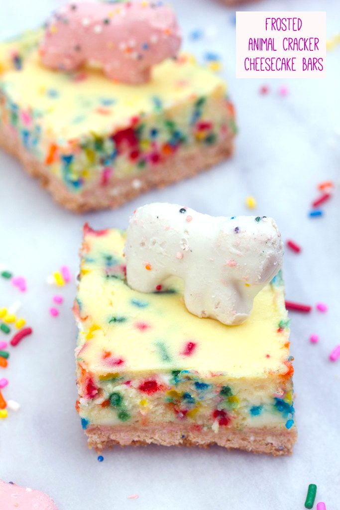 Overhead view of frosted animal cracker cheesecake bar with white animal cracker on top with second bar in the background, rainbow sprinkles scattered around, and recipe title at top