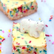 Frosted Animal Cracker Cheesecake Bars -- These Frosted Animal Cracker Cheesecake Bars consist of funfetti cheesecake with a circus animal cookie crust. Basically, your childhood in cheesecake form! | wearenotmartha.com