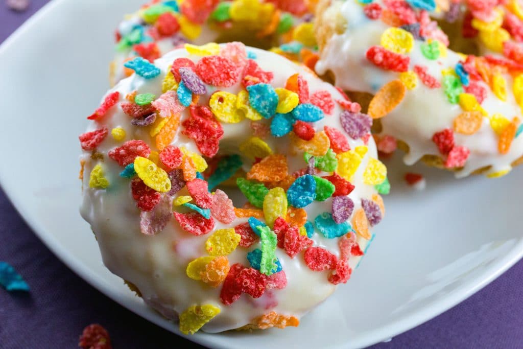 Close up of a Fruity Pebbles Doughnut on a white plate