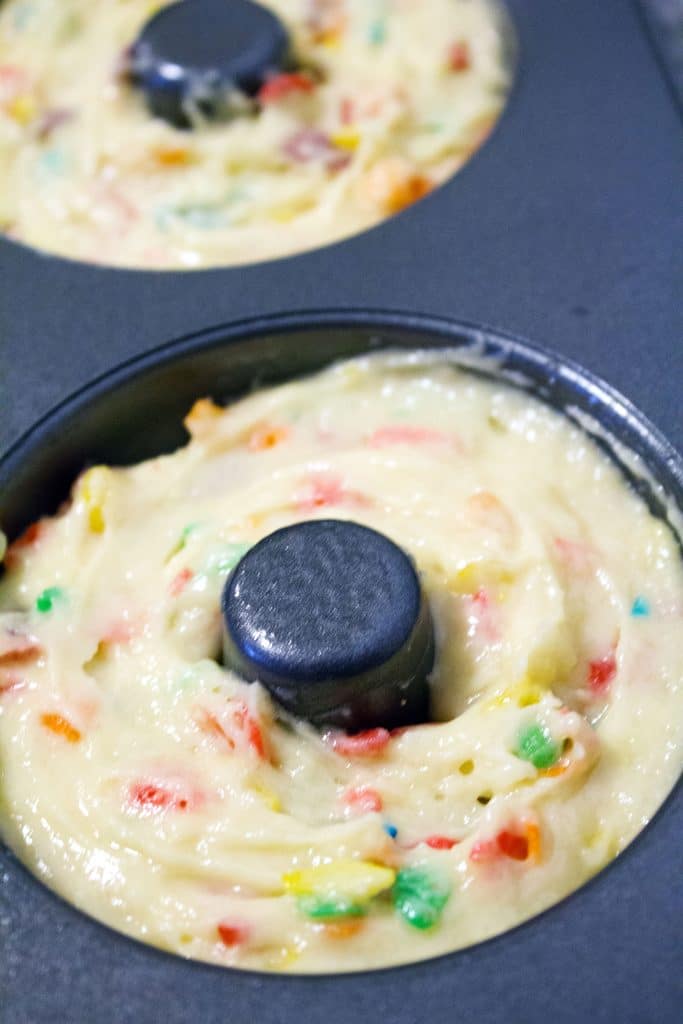 A closeup of a doughnut pan filled with Fruity Pebbles doughnut batter