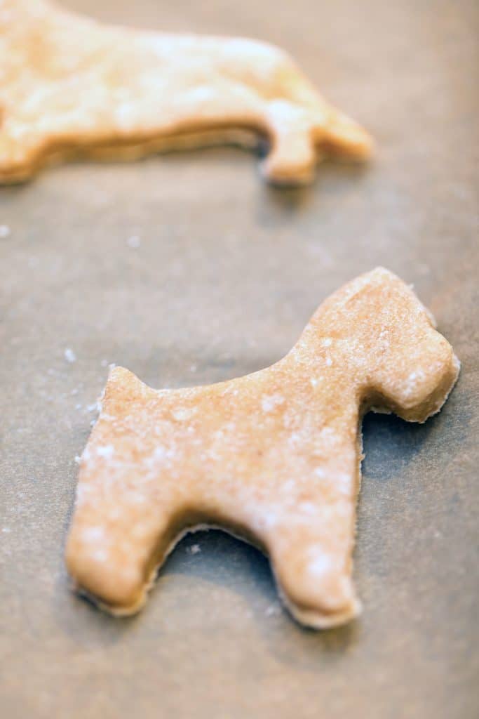 Dog-shaped gingerbread cookie on baking sheet