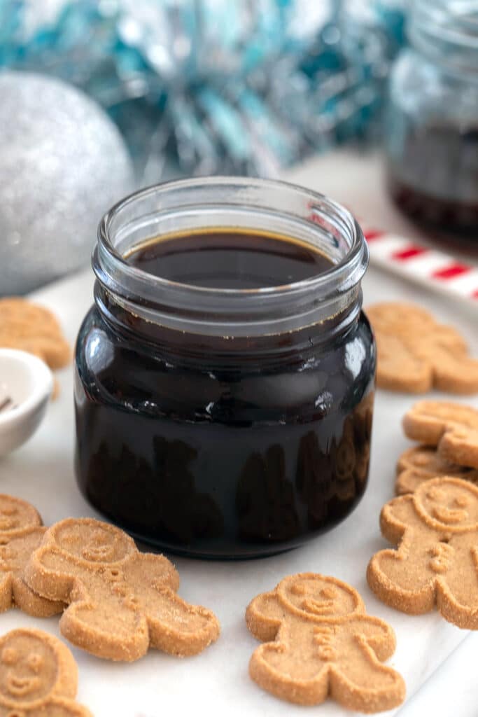 Head-on view of a small jar of gingerbread syrup with gingerbread men all around.
