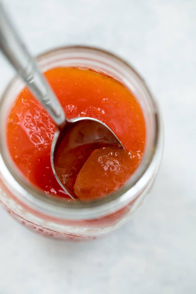 Homemade grapefruit jam in a jar with a spoon