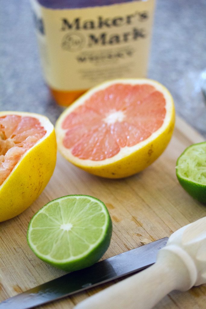 Grapefruits and Lime on cutting board with Maker's Mark
