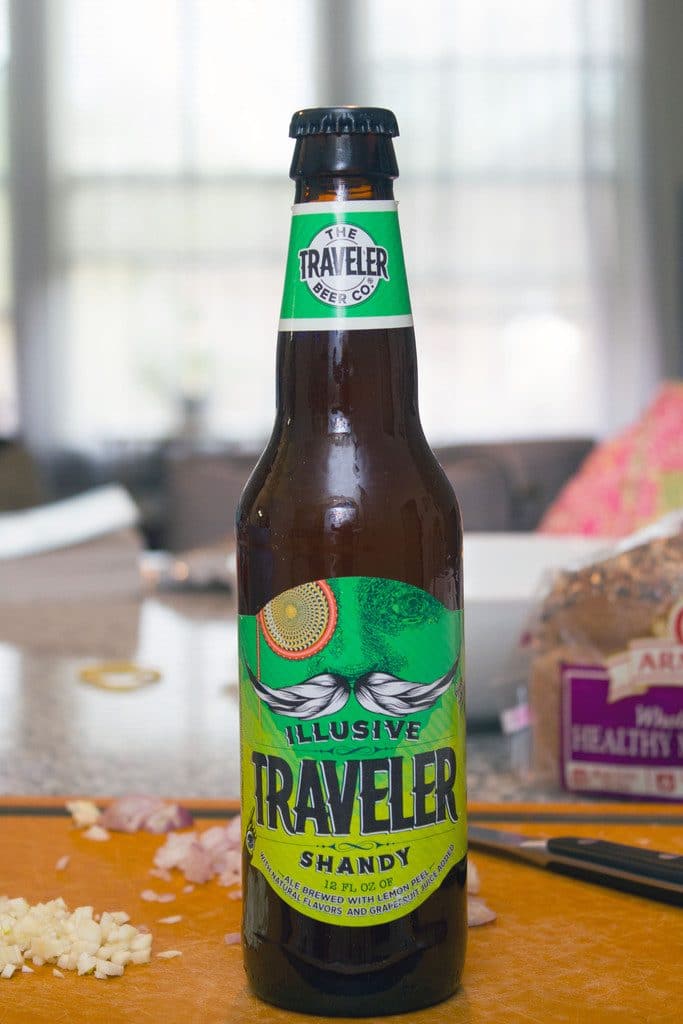 Head-on view of Illusive Traveler Grapefruit Shandy beer bottle on a cutting board