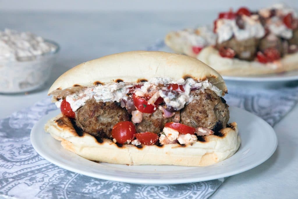 Greek Meatball Subs with Spicy Tzatziki -- These meatball subs will satisfy all of your Greek food cravings. The lamb meatballs are packed with kalamata olives, red onion, feta cheese, and mint and the spicy tzatziki has the perfect kick | wearenotmartha.com