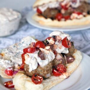 Greek Meatball Subs with Spicy Tzatziki -- These meatball subs will satisfy all of your Greek food cravings. The lamb meatballs are packed with kalamata olives, red onion, feta cheese, and mint and the spicy tzatziki has the perfect kick | wearenotmartha.com