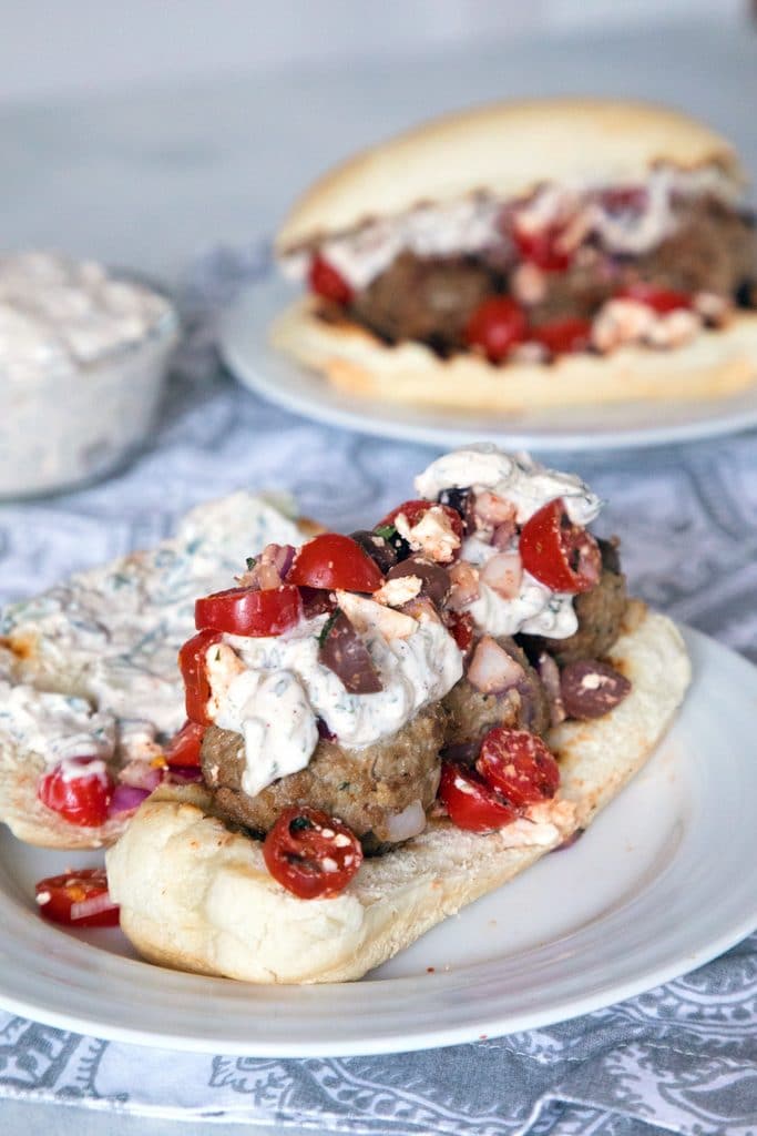 Greek Meatball Subs with Spicy Tzatziki -- These meatball subs will satisfy all of your Greek food cravings. The lamb meatballs are packed with kalamata olives, red onion, feta cheese, and mint and the spicy tzatziki has the perfect kick | wearenotmartha.com