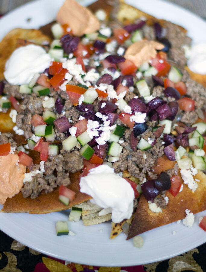 Greek Nachos with Ground Lamb -- Ever crave nachos for dinner? These Greek Nachos with Ground Lamb are piled high with veggies and hummus, making them a totally acceptable dinner. Promise. | wearenotmartha.com